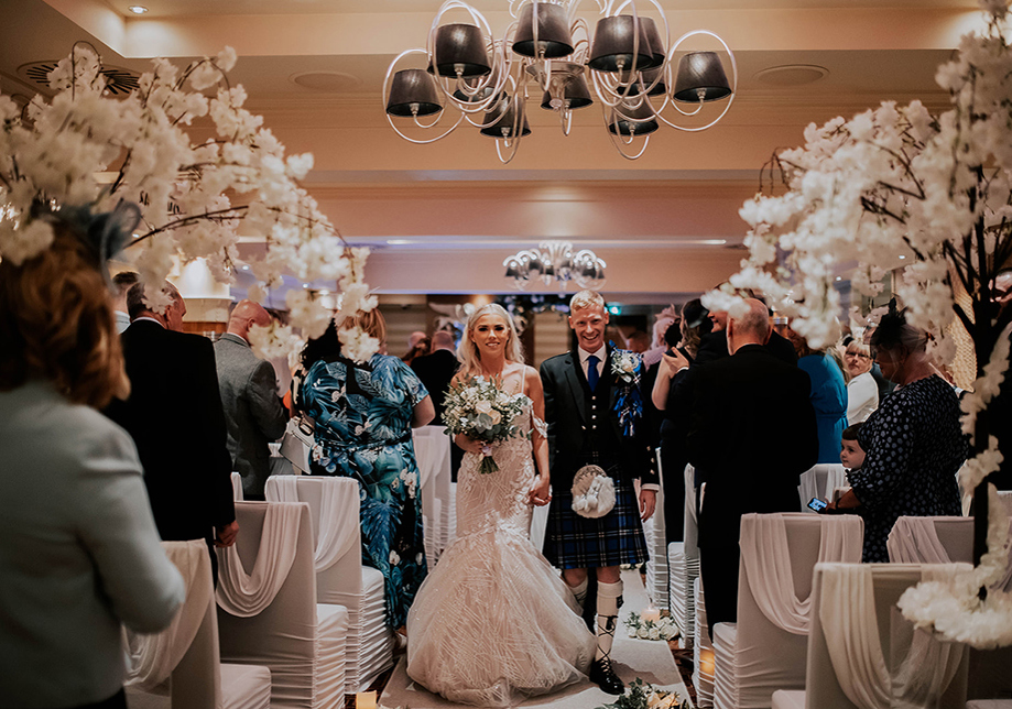 Bride and groom walking back down aisle following their ceremony